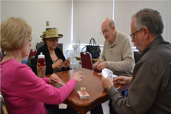 Picture of 2 woman and 2 men playing cards at a table in the Senior Center