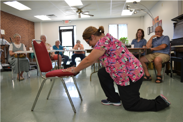 Picture of a woman exercising in front of a group of people at the Senior Center